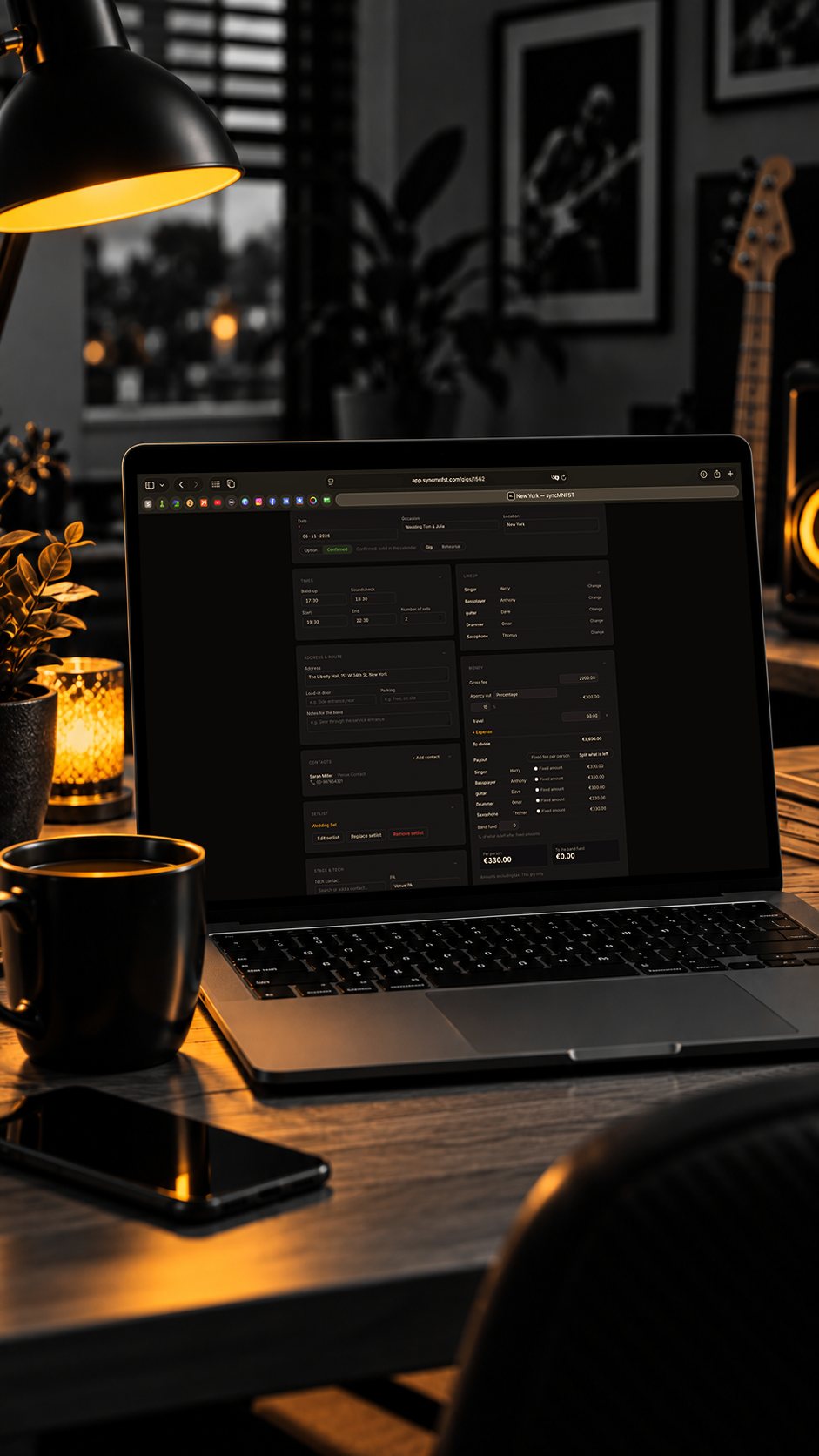 Laptop on a desk at night with the syncMNFST web app open on a gig page